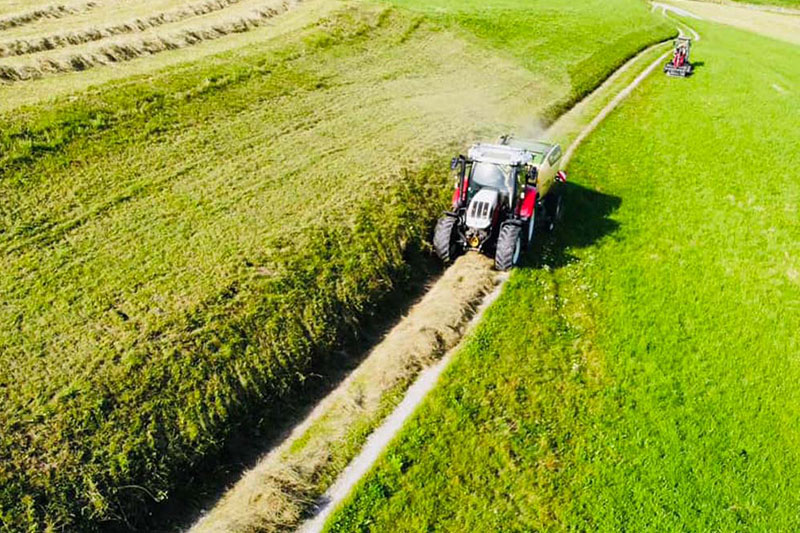 Traktor pflügt Feld bei Innsbruck