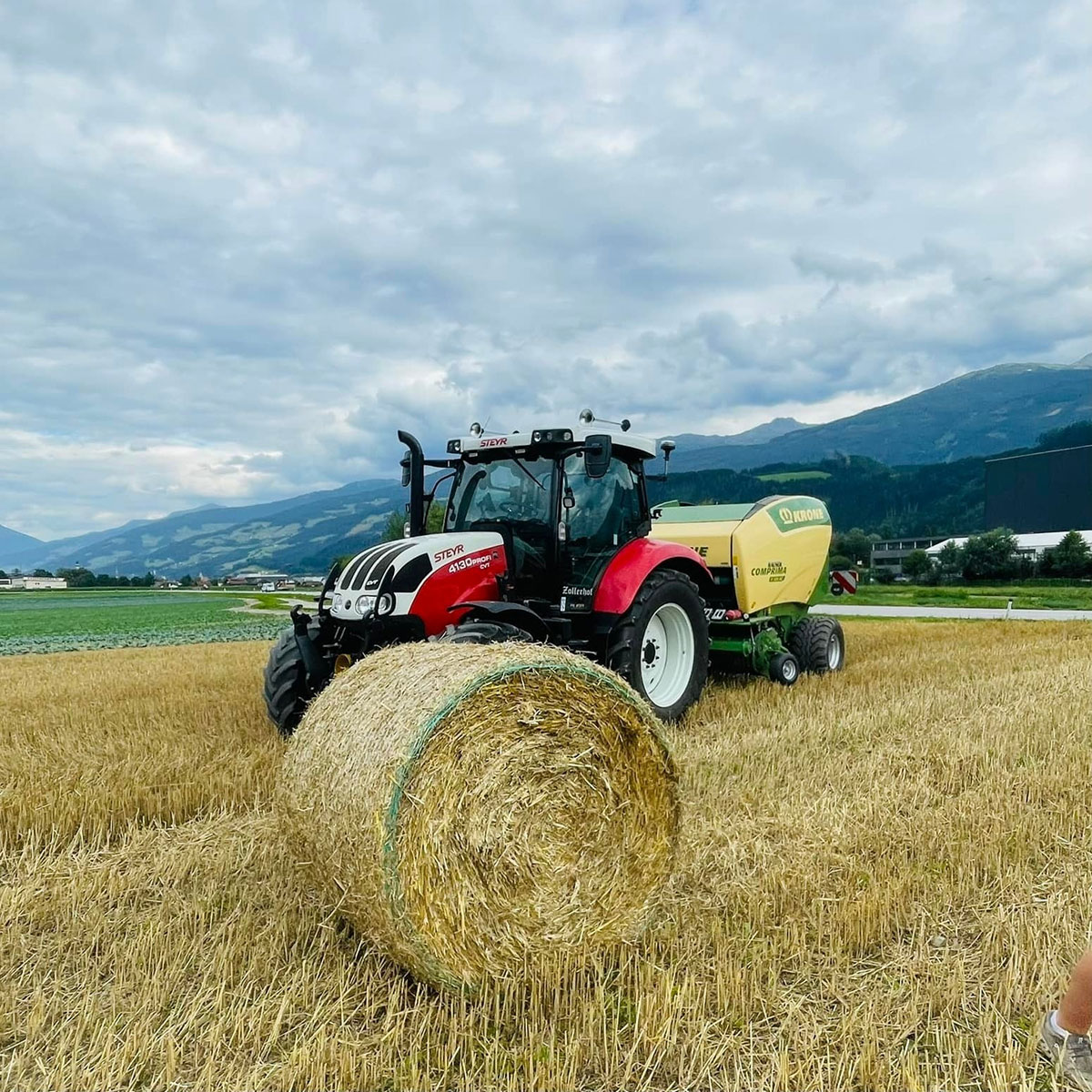 Traktor am Feld mit Heuballen